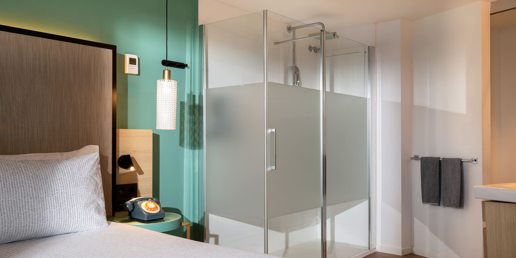 a room with a bed and glass shower