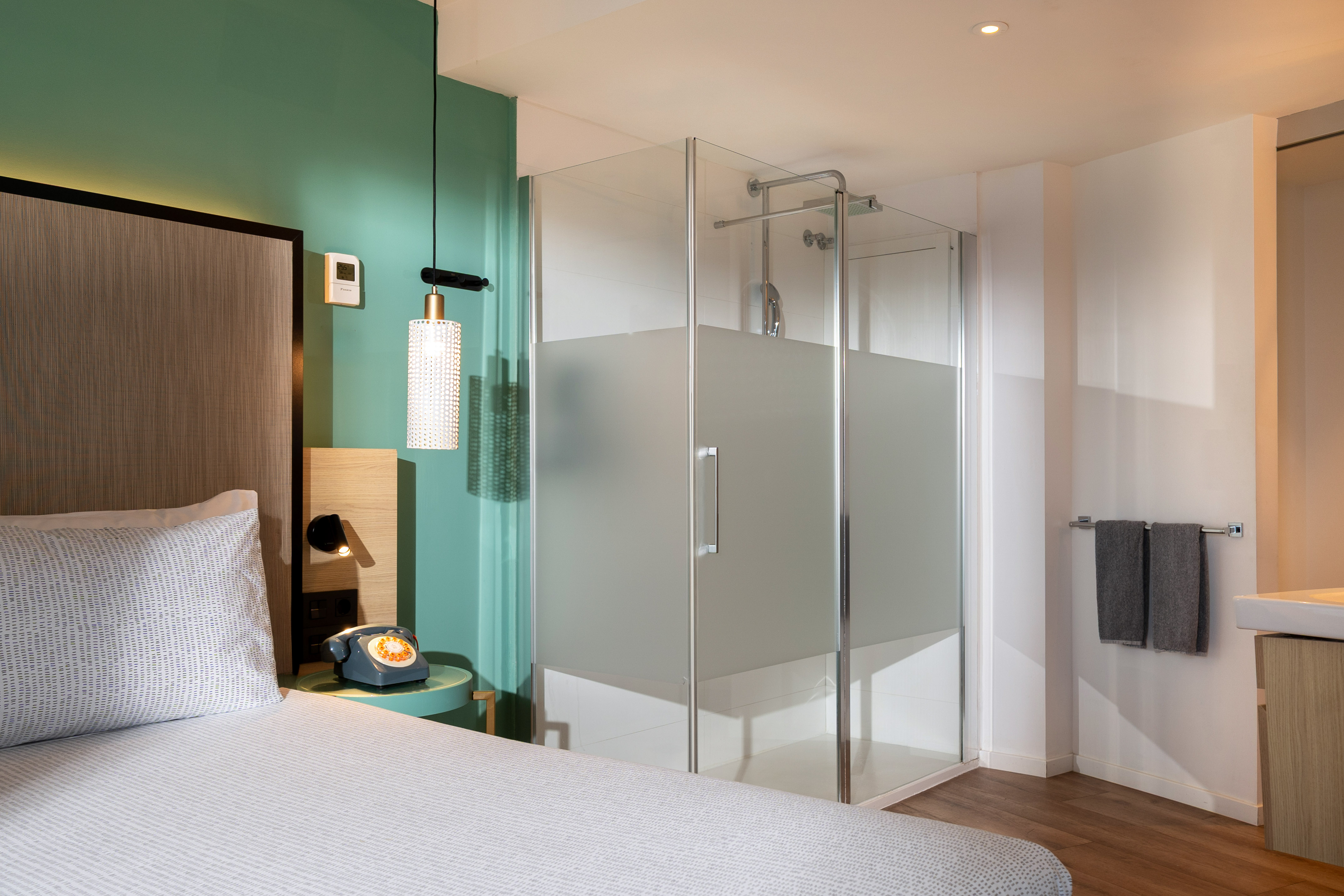 a room with a bed and glass shower
