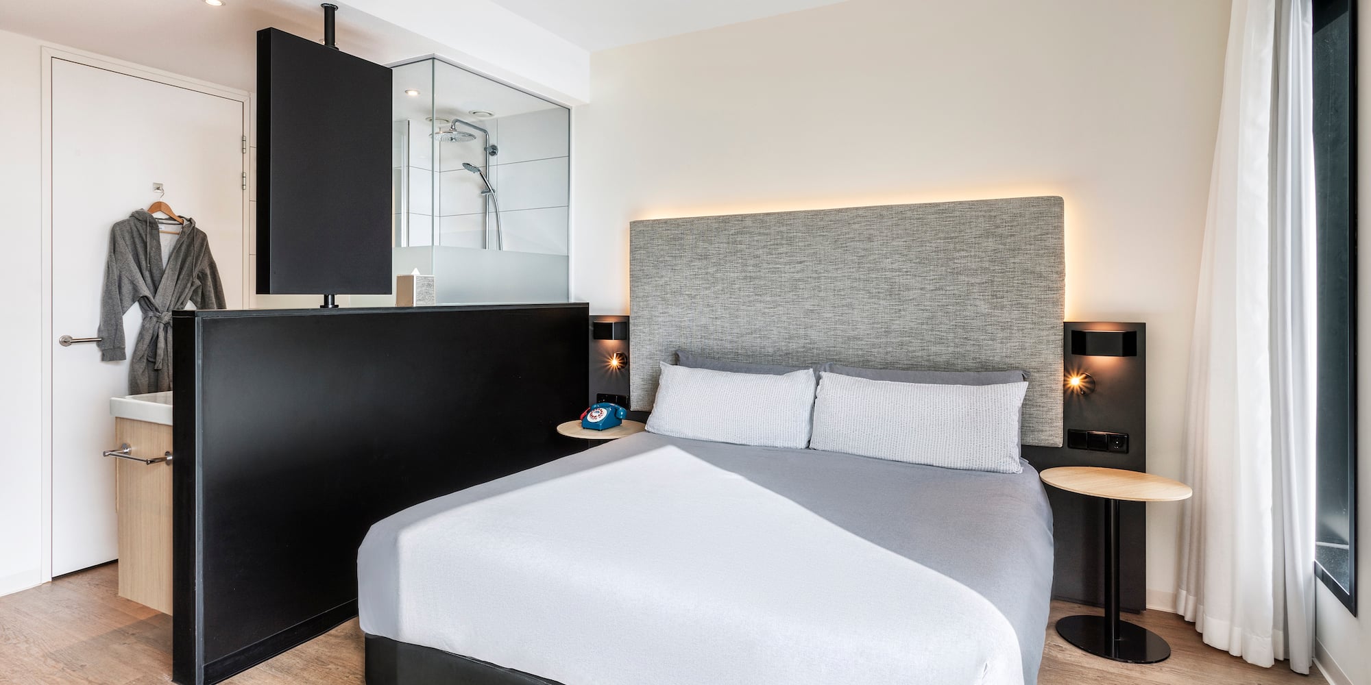 a bed with a black headboard and a black and white wall