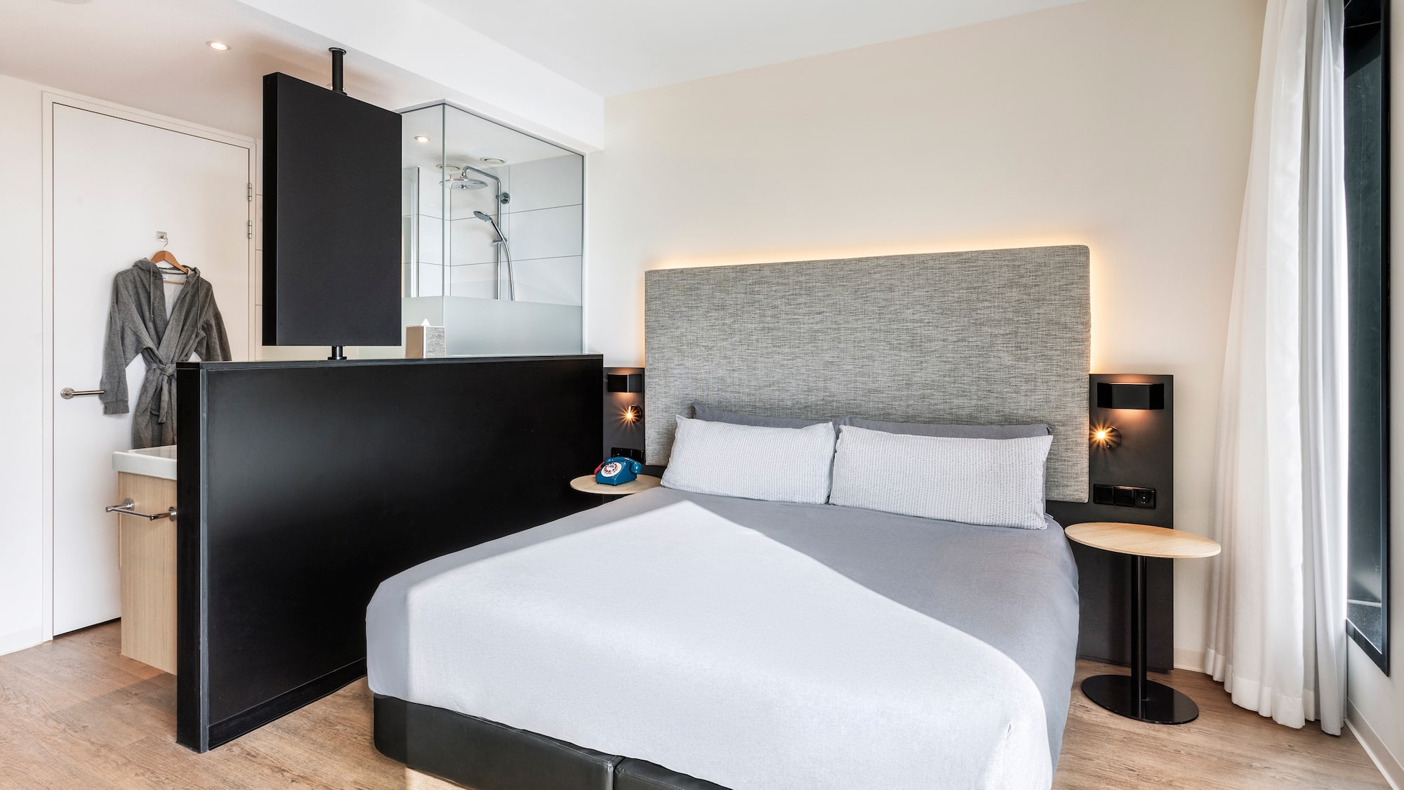 a bed with a black headboard and a black and white wall