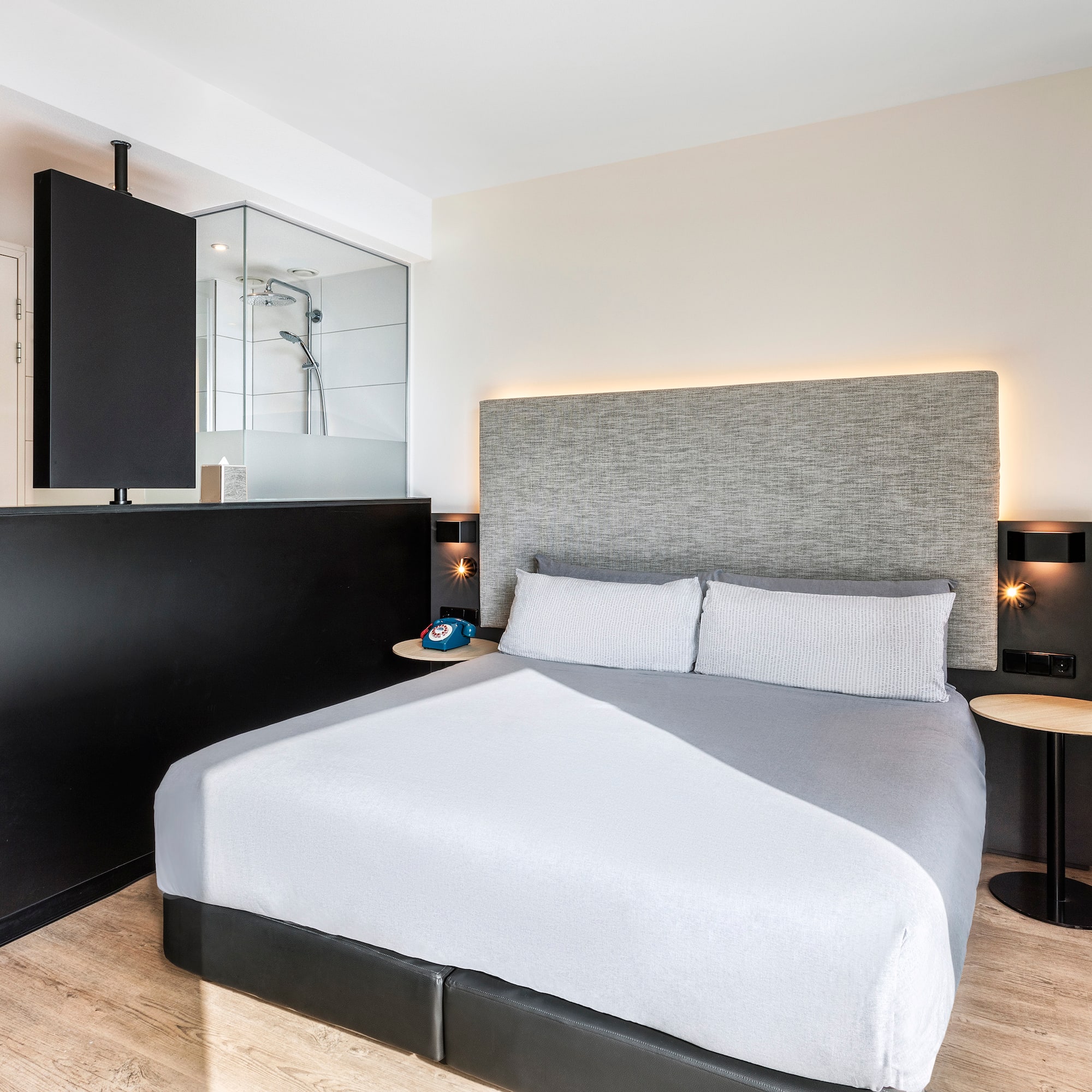 a bed with a black headboard and a black and white wall