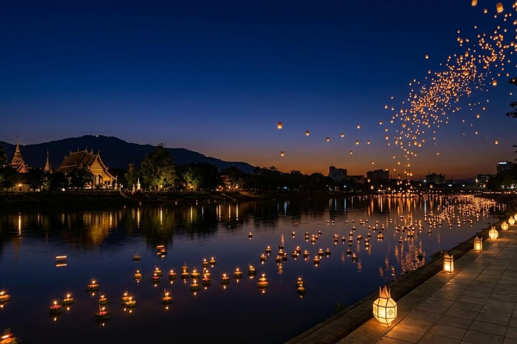 Yi Peng Loy Krathong festival at dusk with sky and river lanterns.