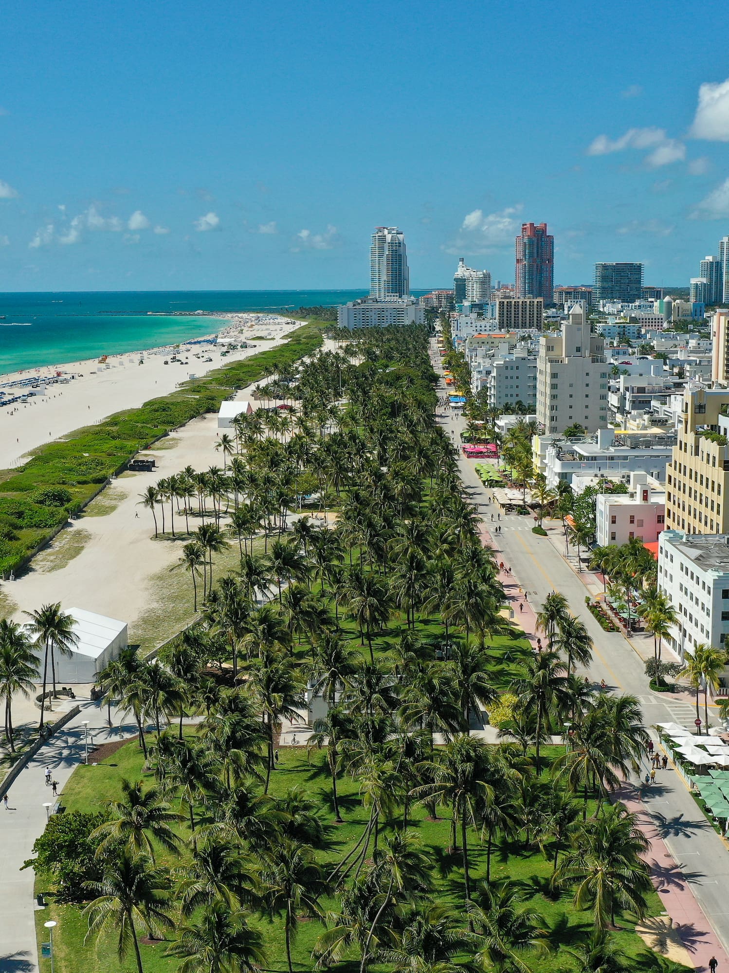 Vista aérea Miami Beach: rascacielos, palmeras, playa y océano turquesa.