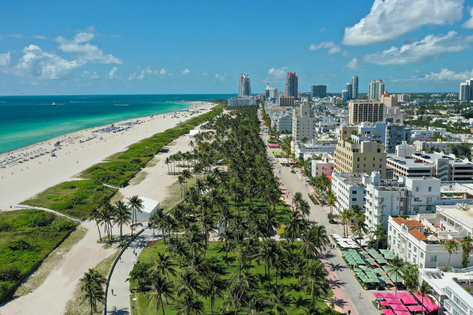 Vista aérea Miami Beach: rascacielos, palmeras, playa y océano turquesa.