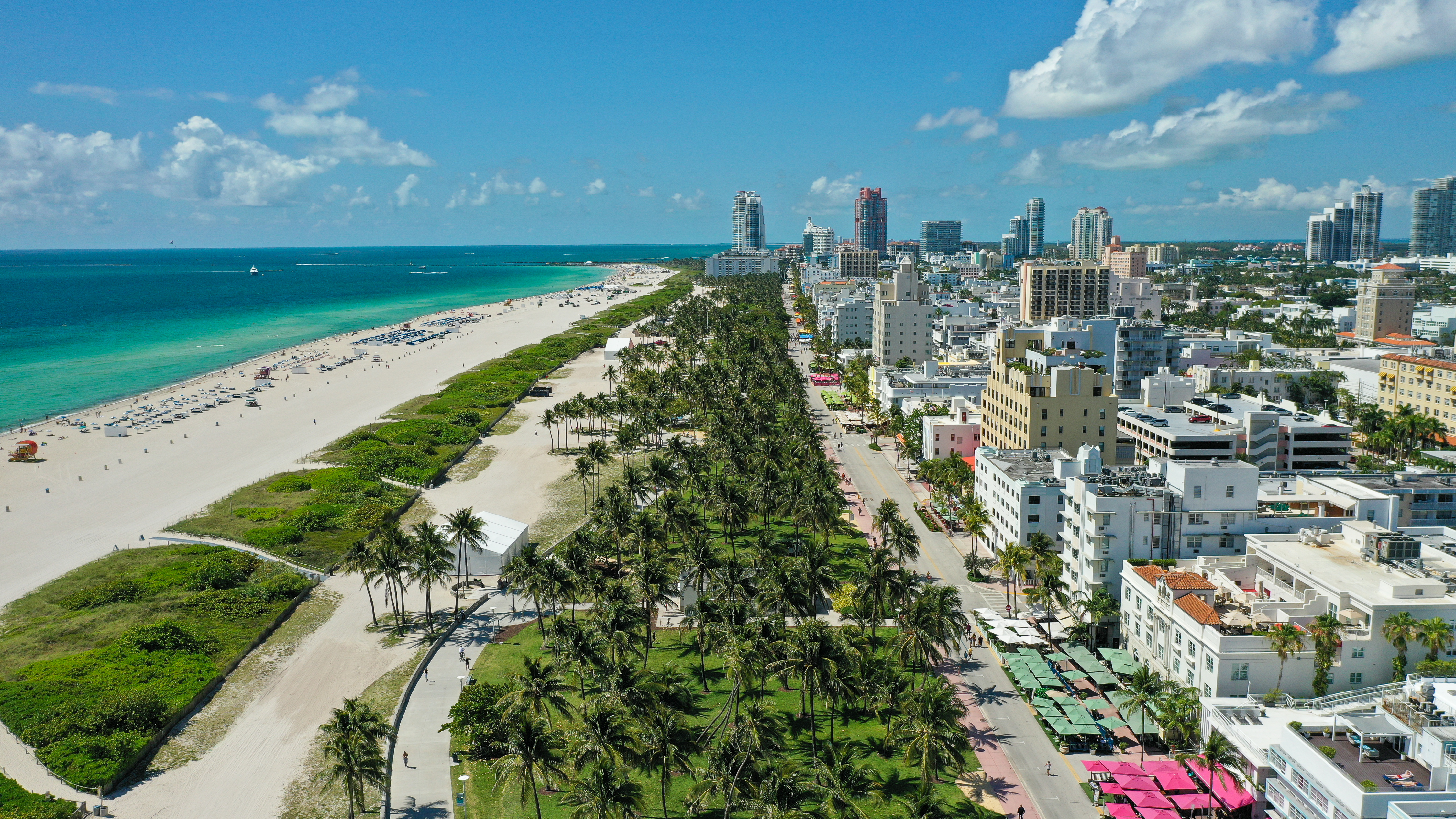 Vista aérea Miami Beach: rascacielos, palmeras, playa y océano turquesa.