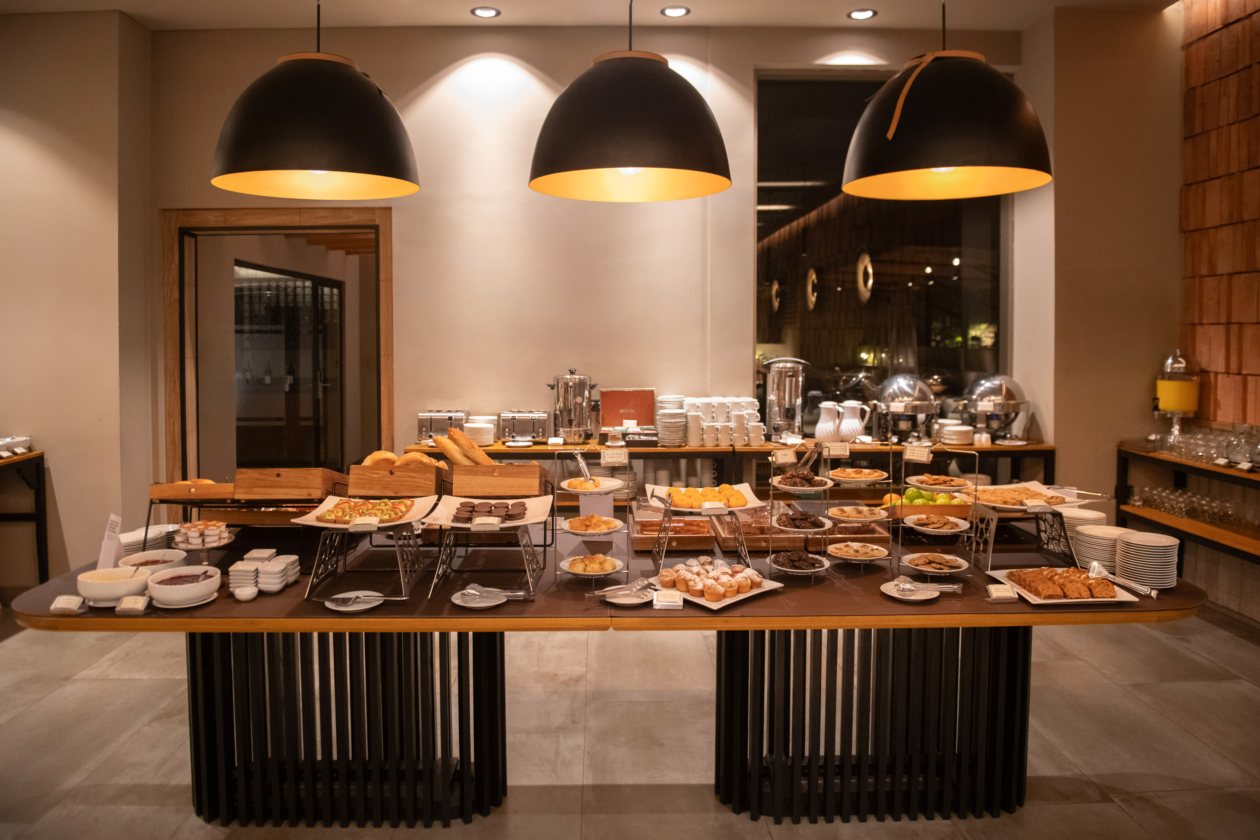 Hotel breakfast buffet with pastries, fresh bread, fruit, and beverages.