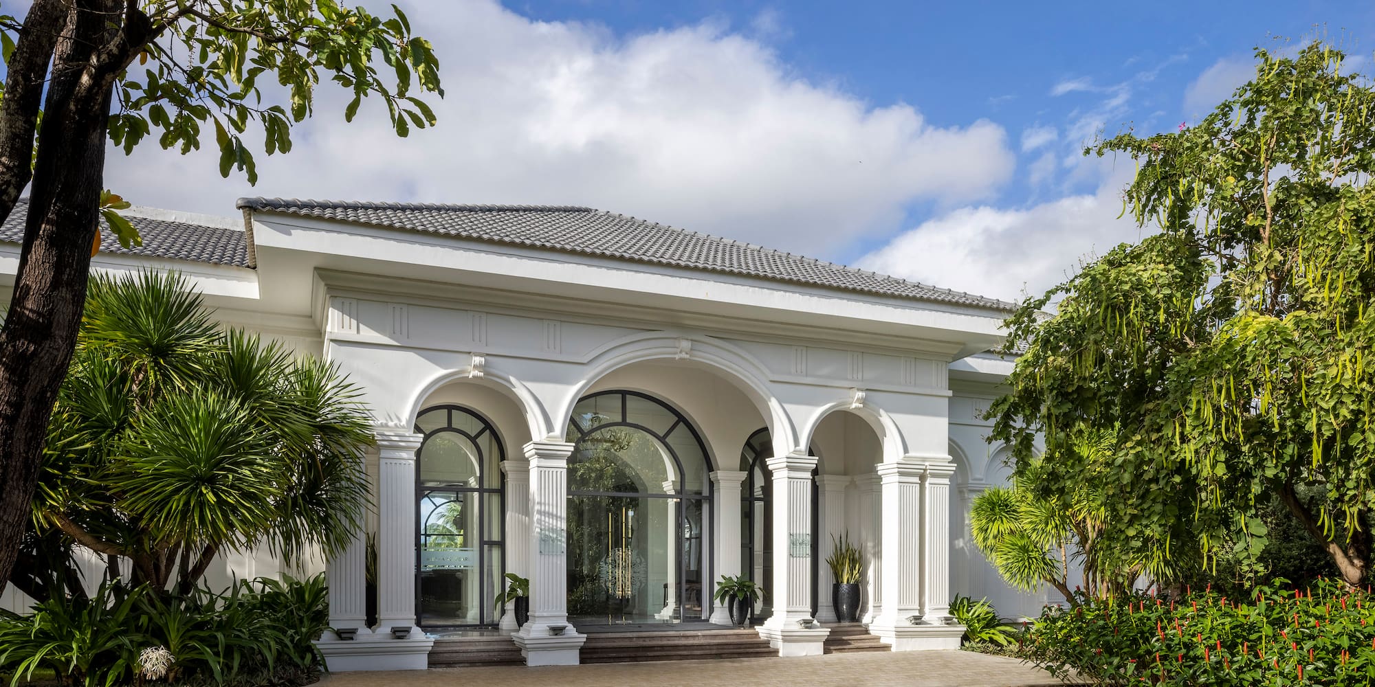 a white building with columns and a lawn