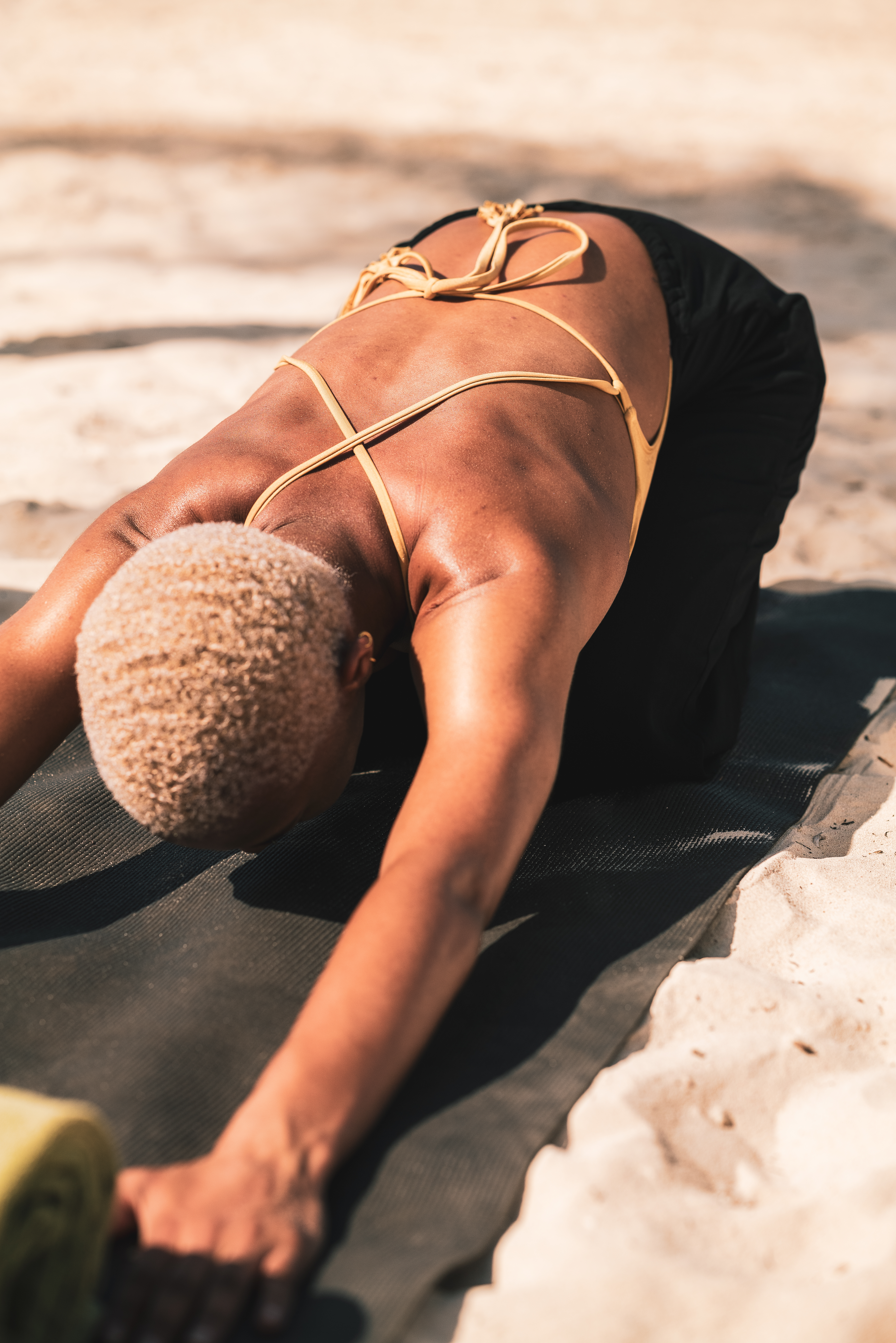 a woman doing yoga on the beach
