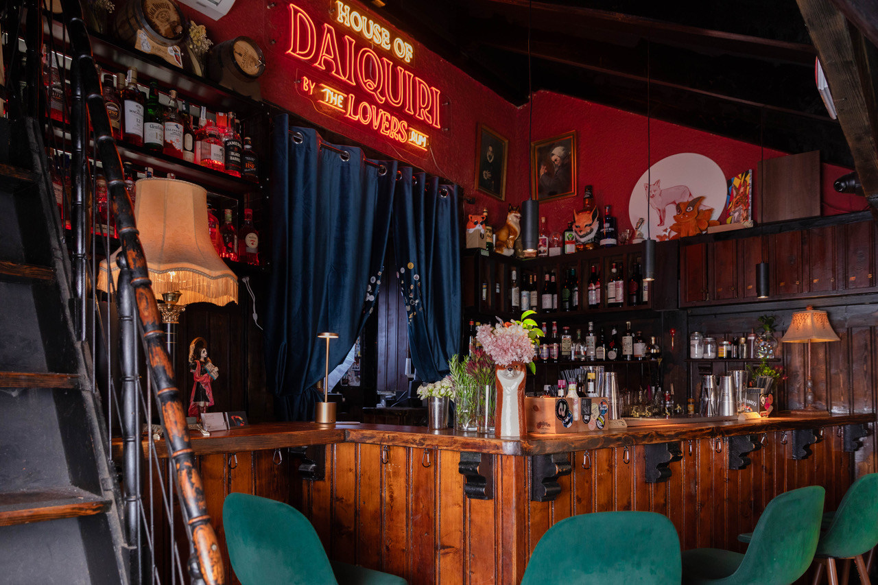 a bar with a red wall and a red sign