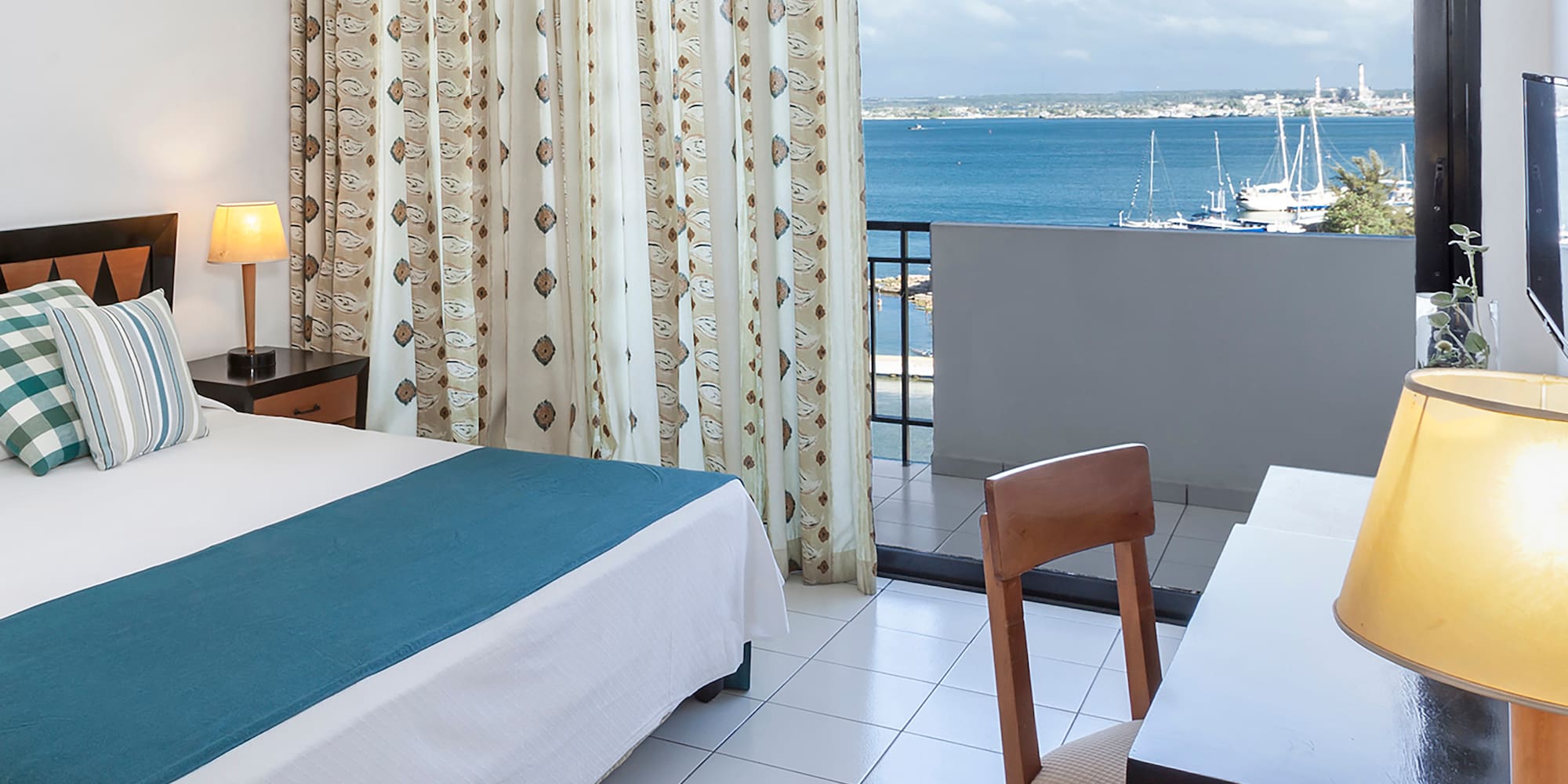 a room with a bed and a window overlooking the water