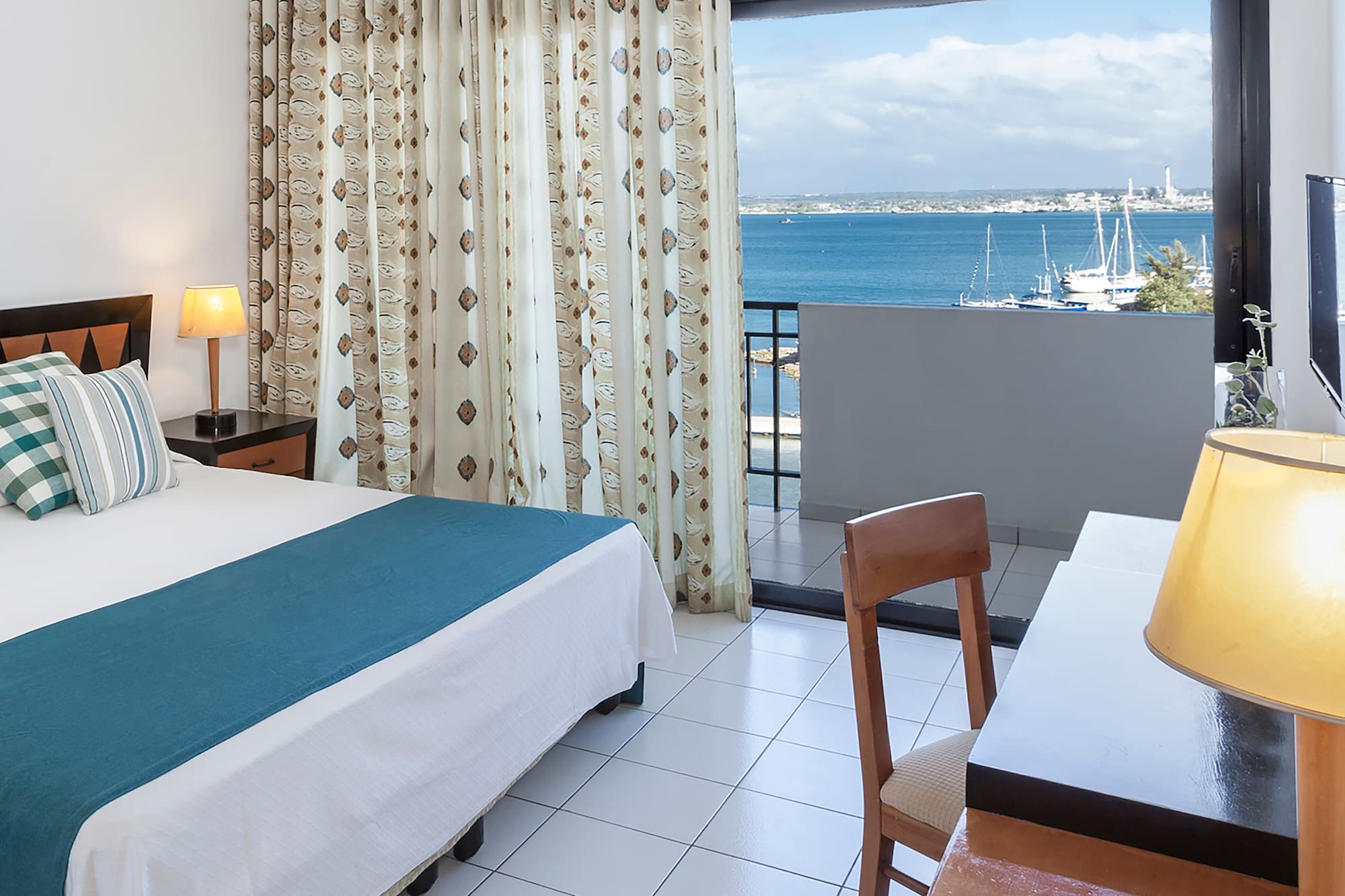 a room with a bed and a window overlooking the water