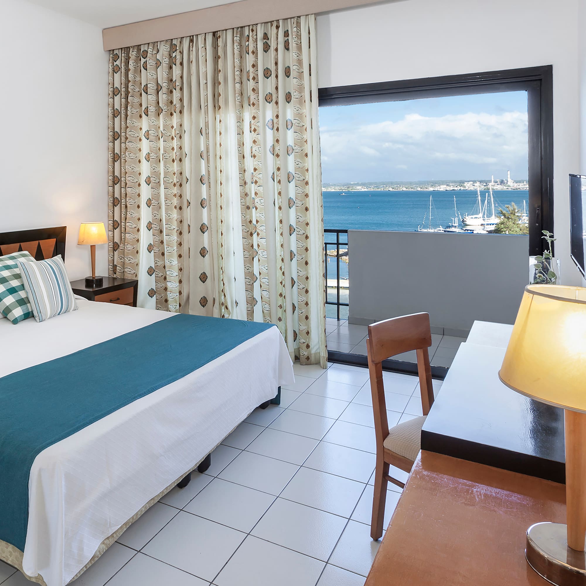 a room with a bed and a window overlooking the water