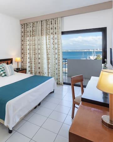 a room with a bed and a window overlooking the water