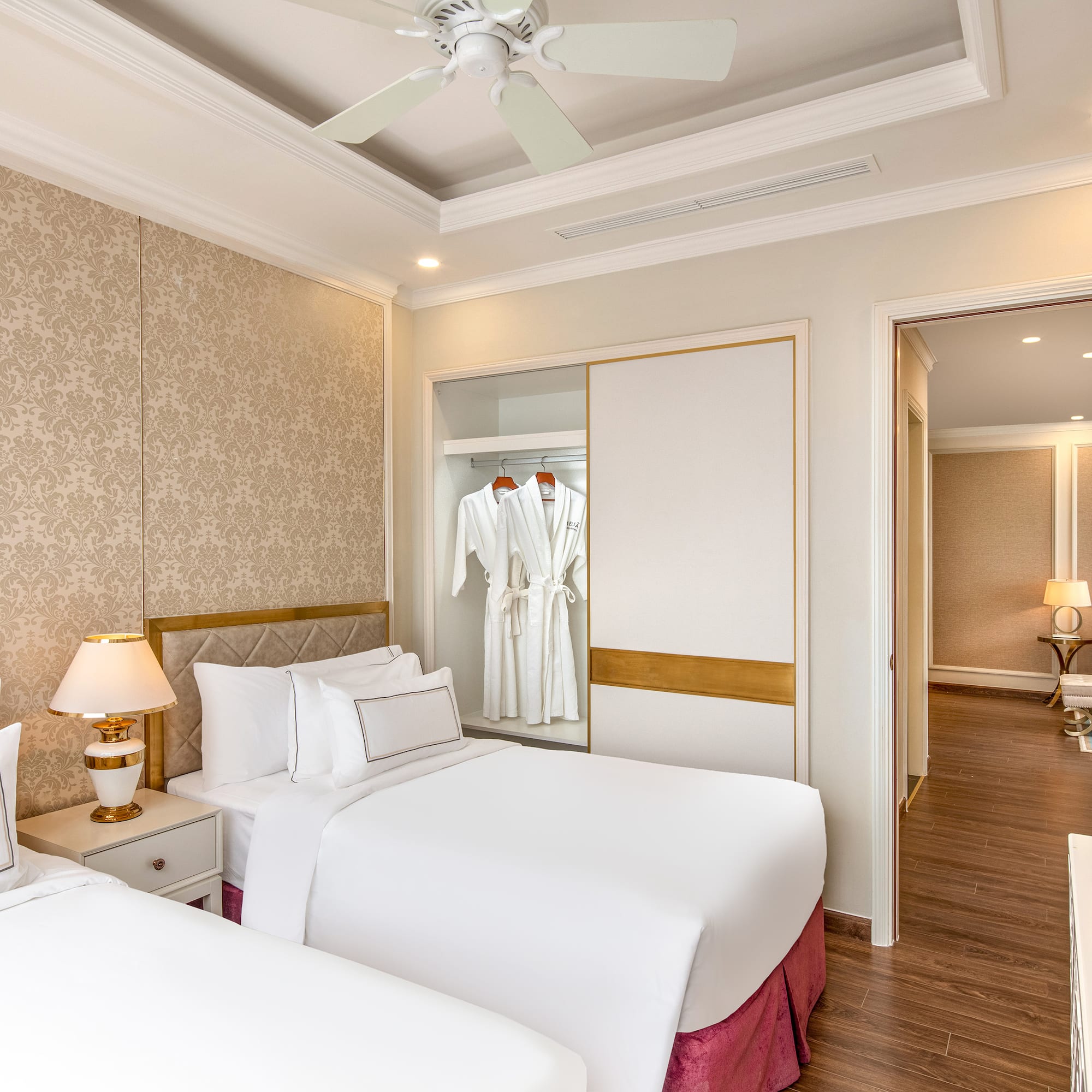 a room with two beds and a ceiling fan