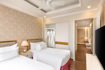 a room with two beds and a ceiling fan