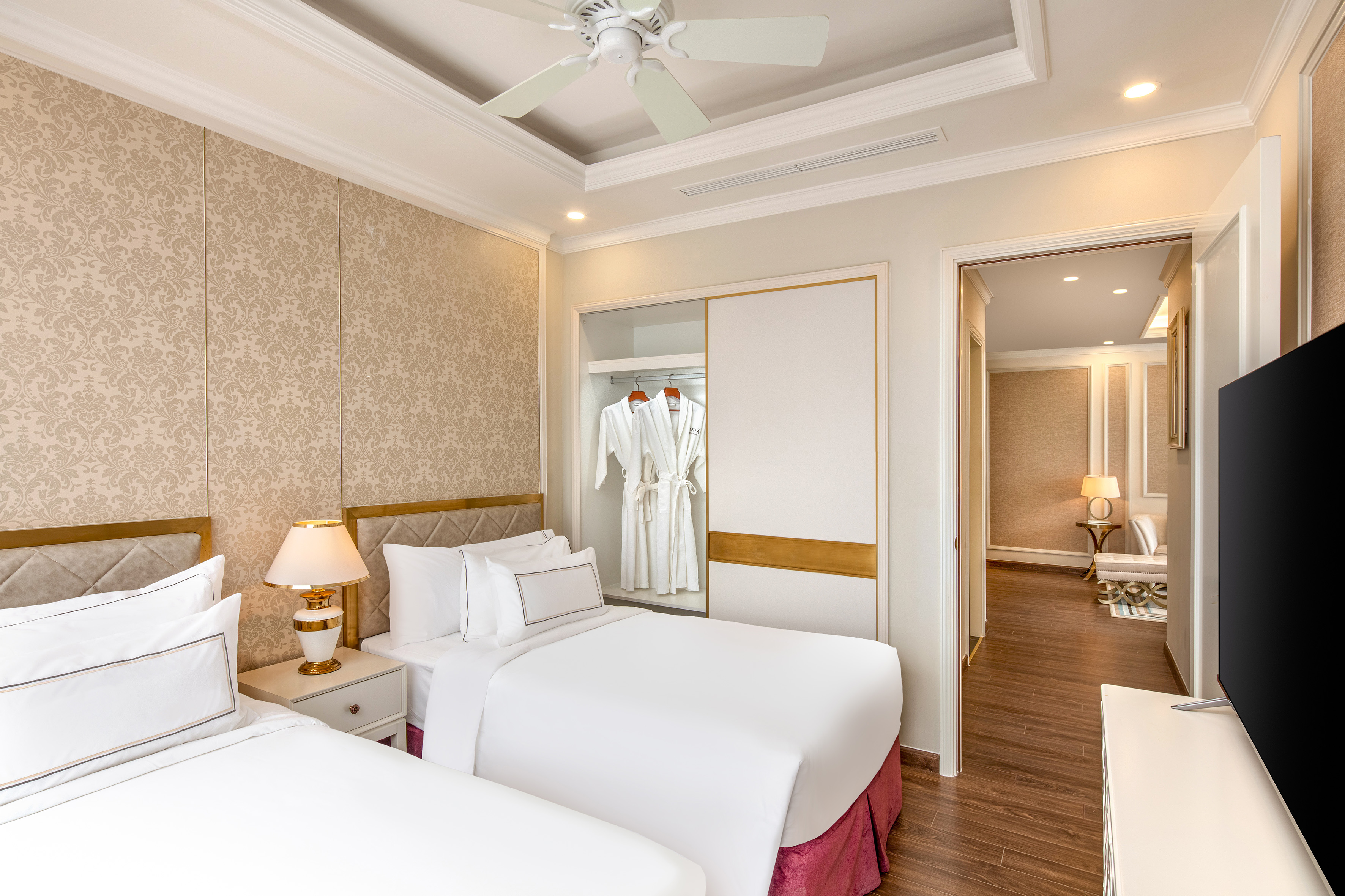 a room with two beds and a ceiling fan