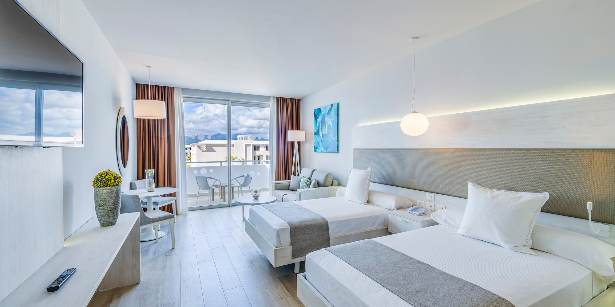 a room with two beds and a table and chairs