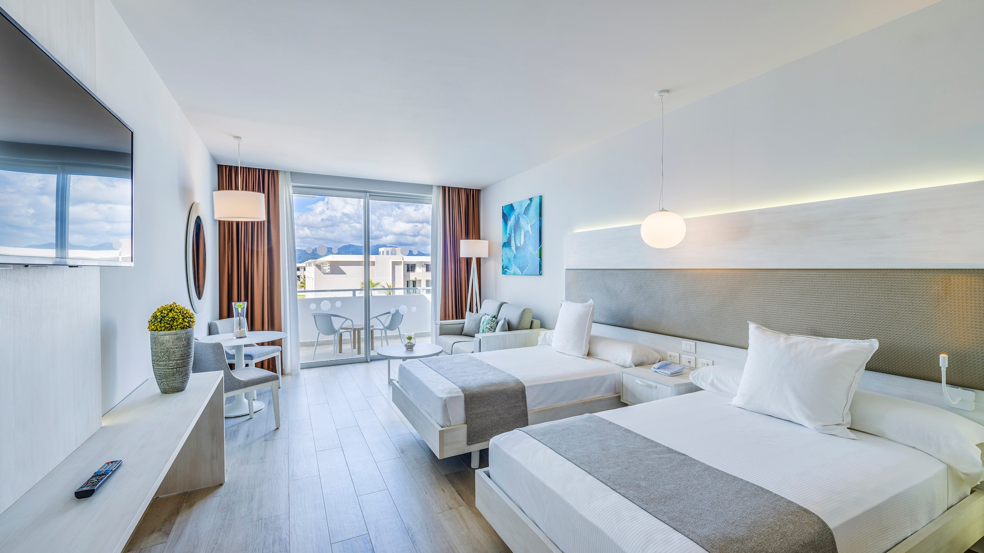 a room with two beds and a table and chairs