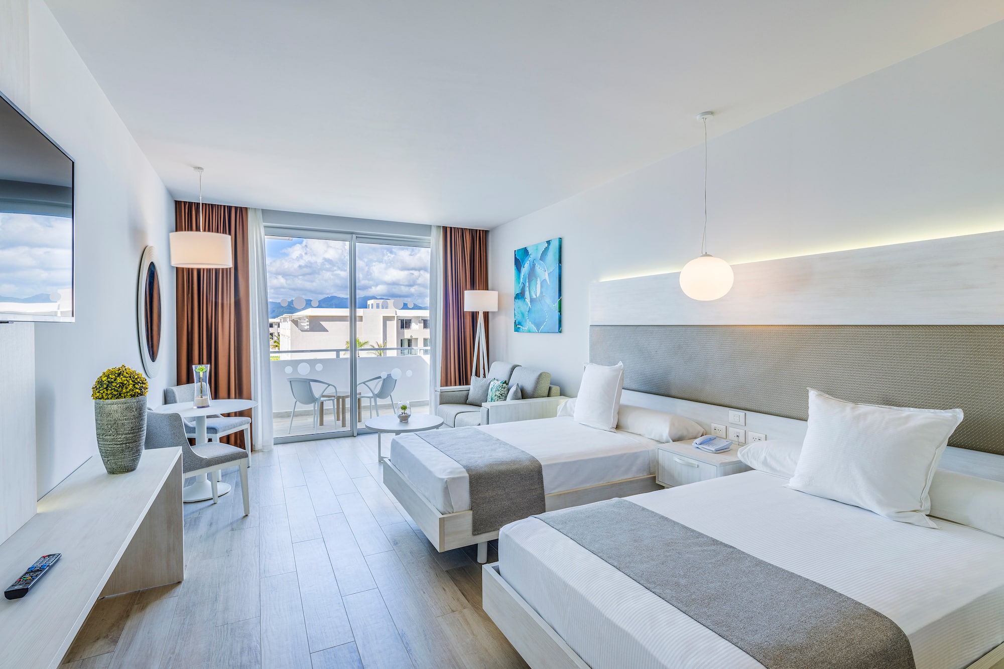 a room with two beds and a table and chairs