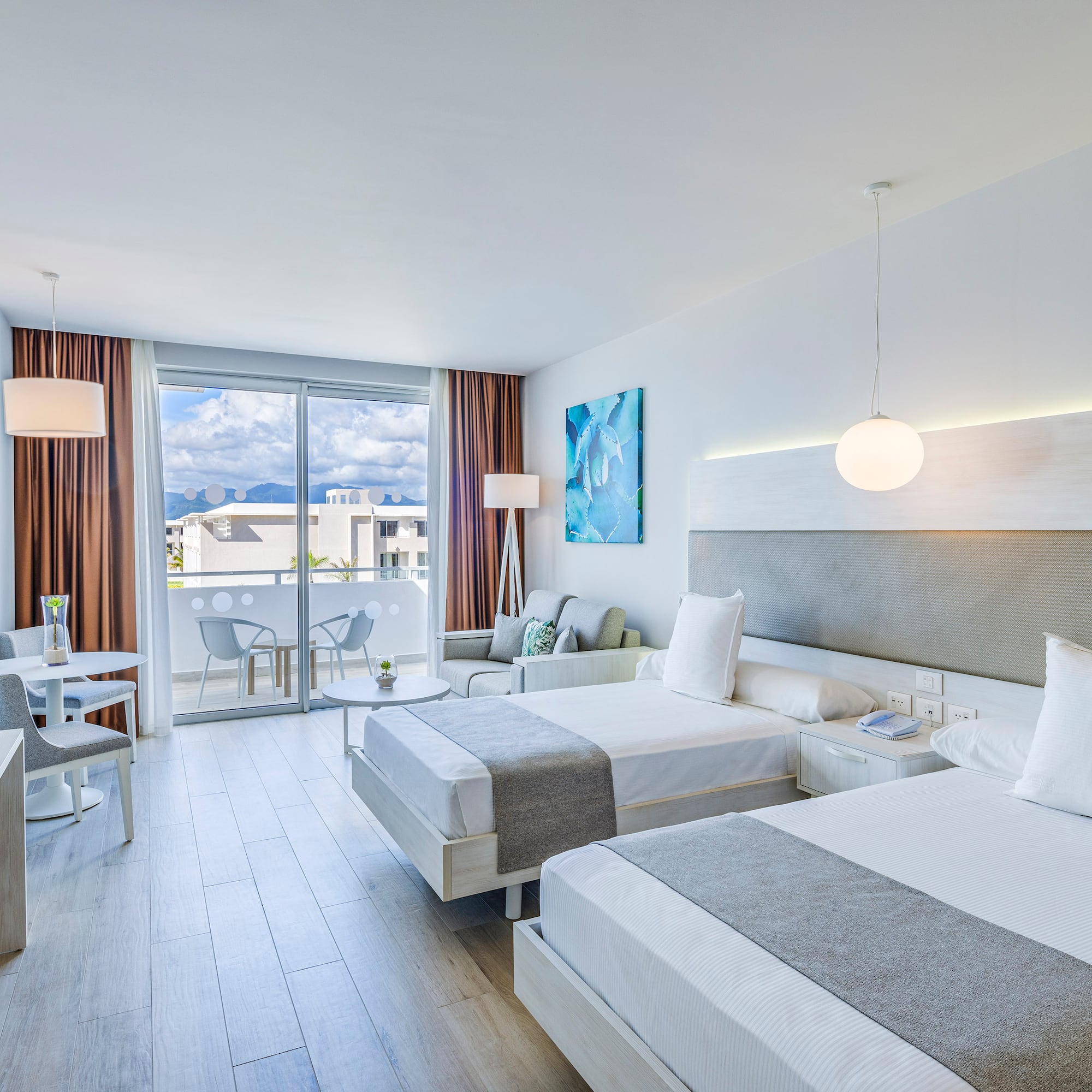 a room with two beds and a table and chairs