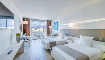 a room with two beds and a table and chairs