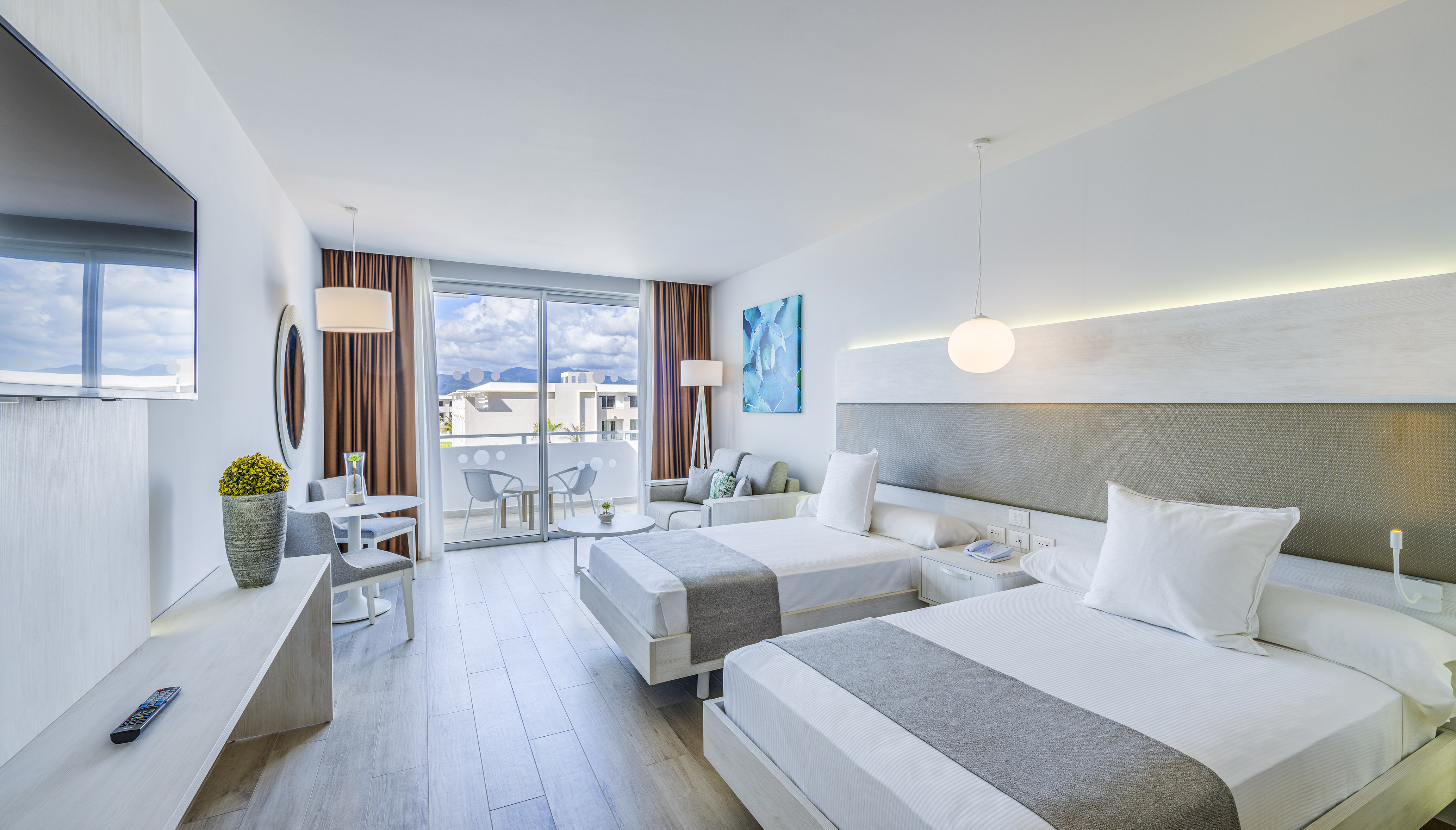 a room with two beds and a table and chairs