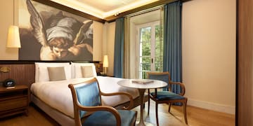 a room with a bed and chairs