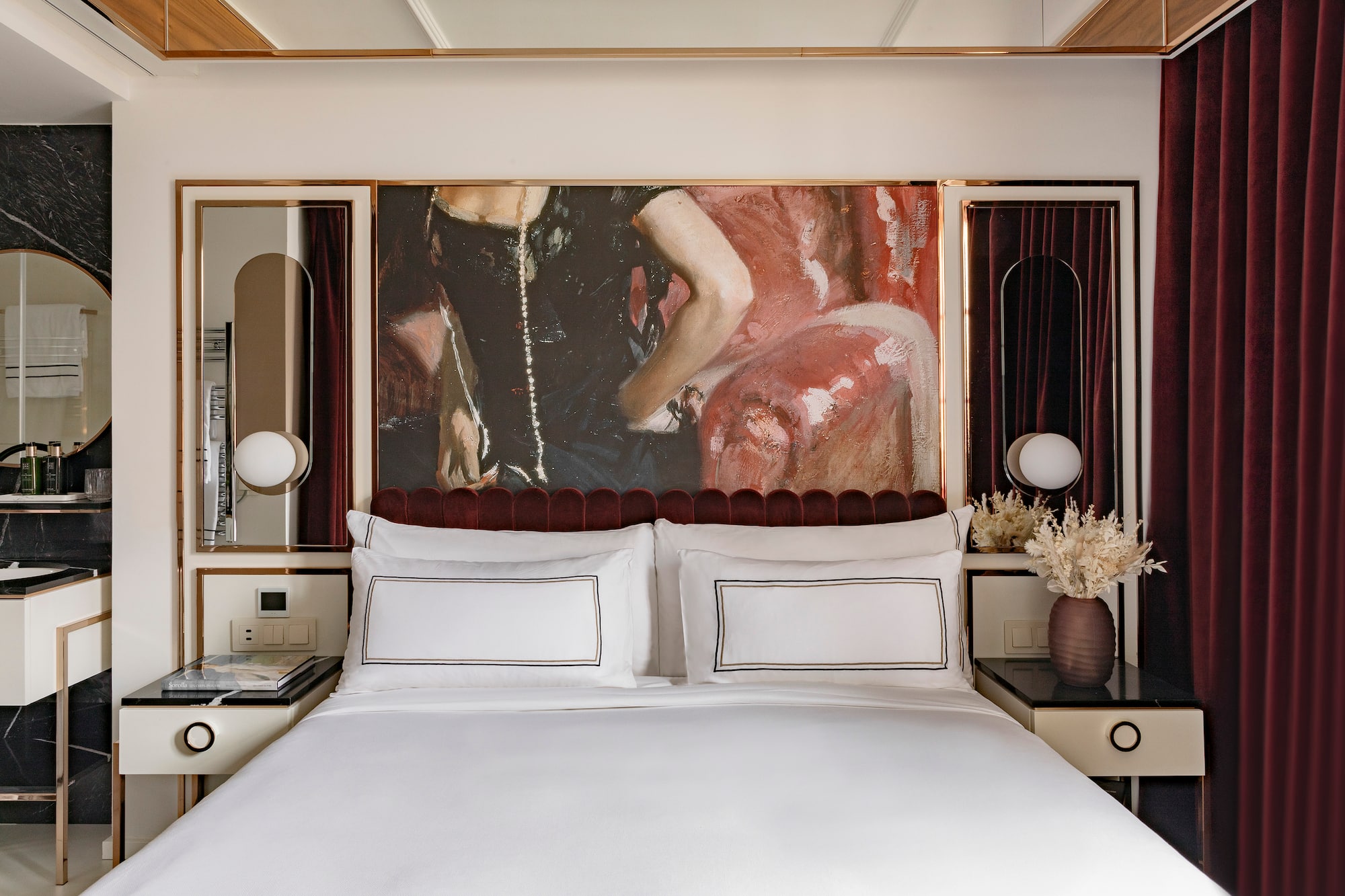 a bed with a painting above it