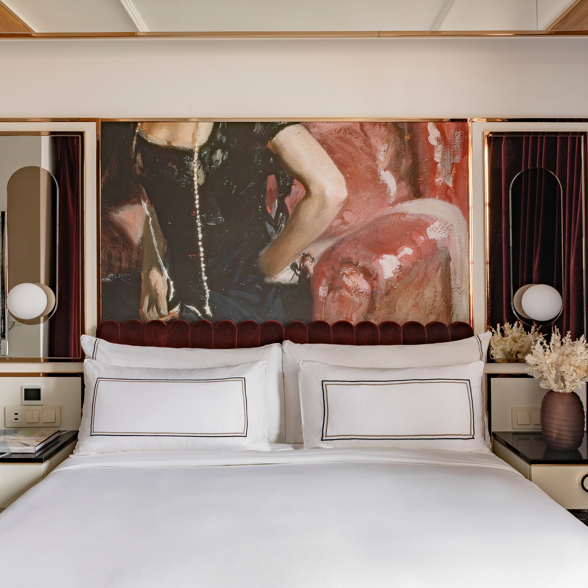 a bed with a painting above it