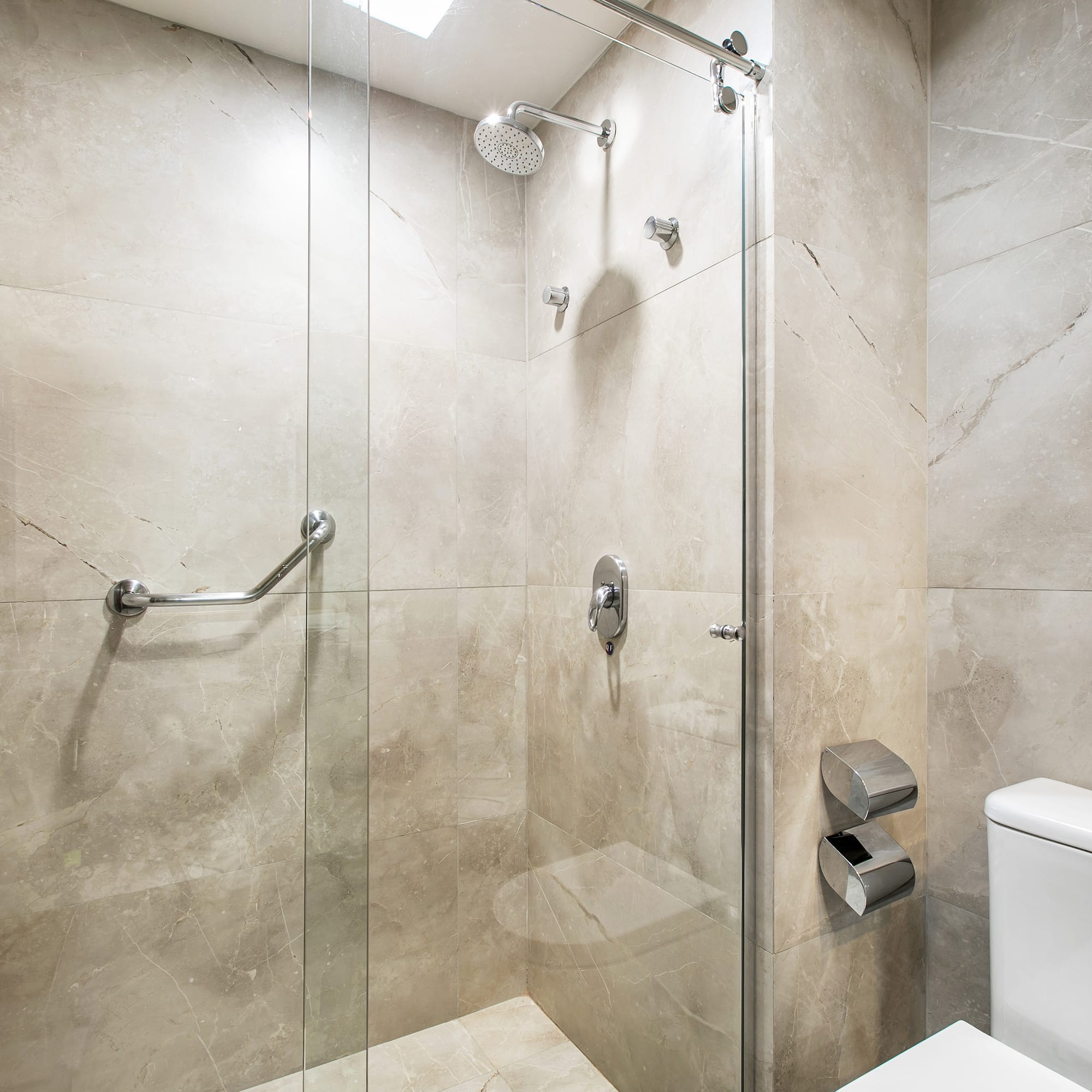 a bathroom with a glass shower and toilet