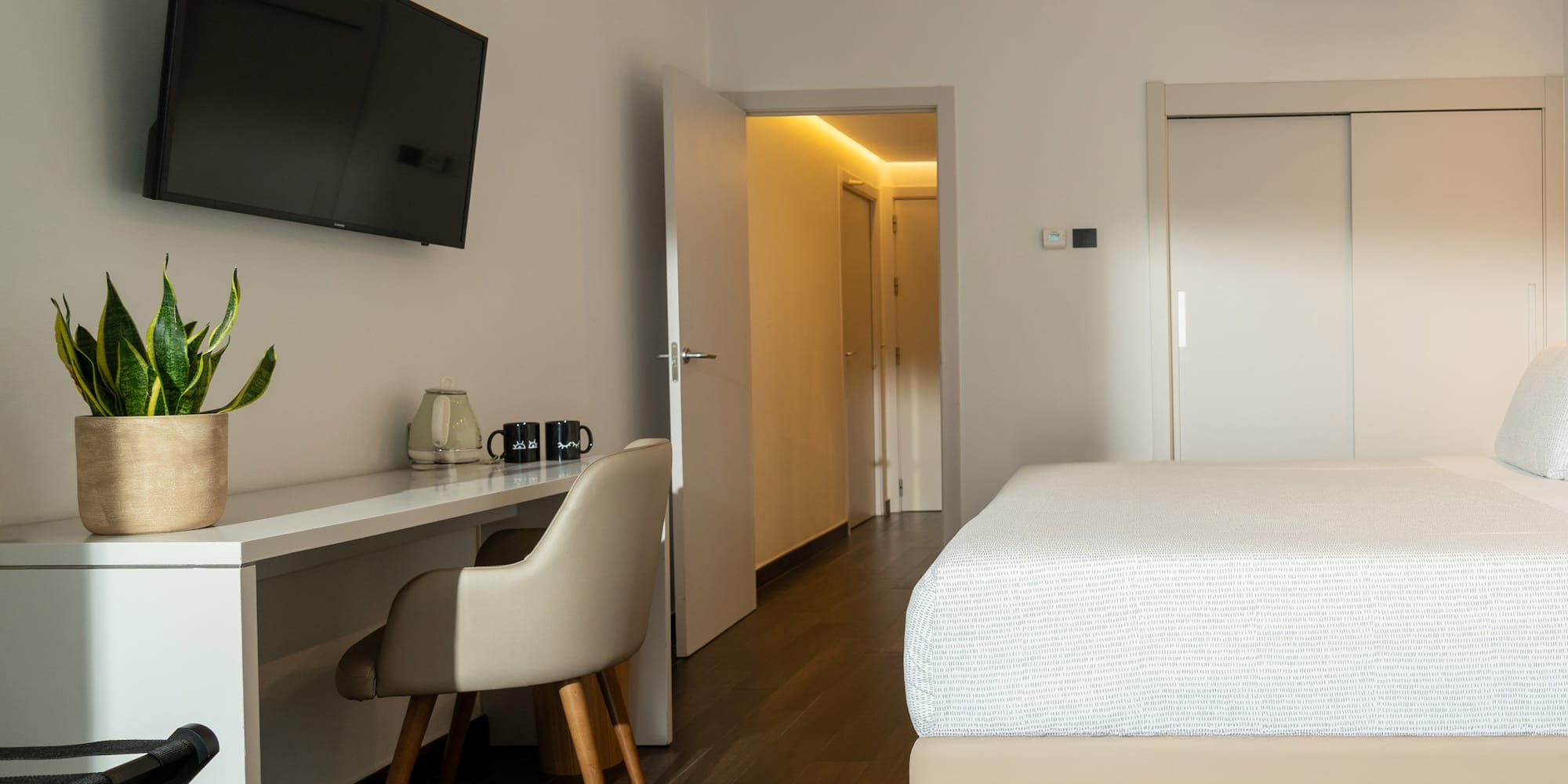 a room with a bed and a desk and a tv