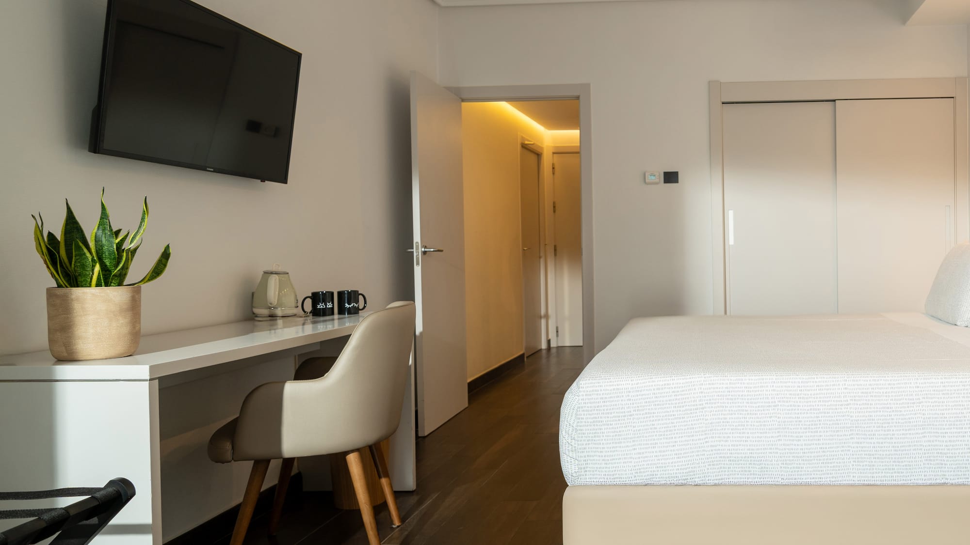 a room with a bed and a desk and a tv