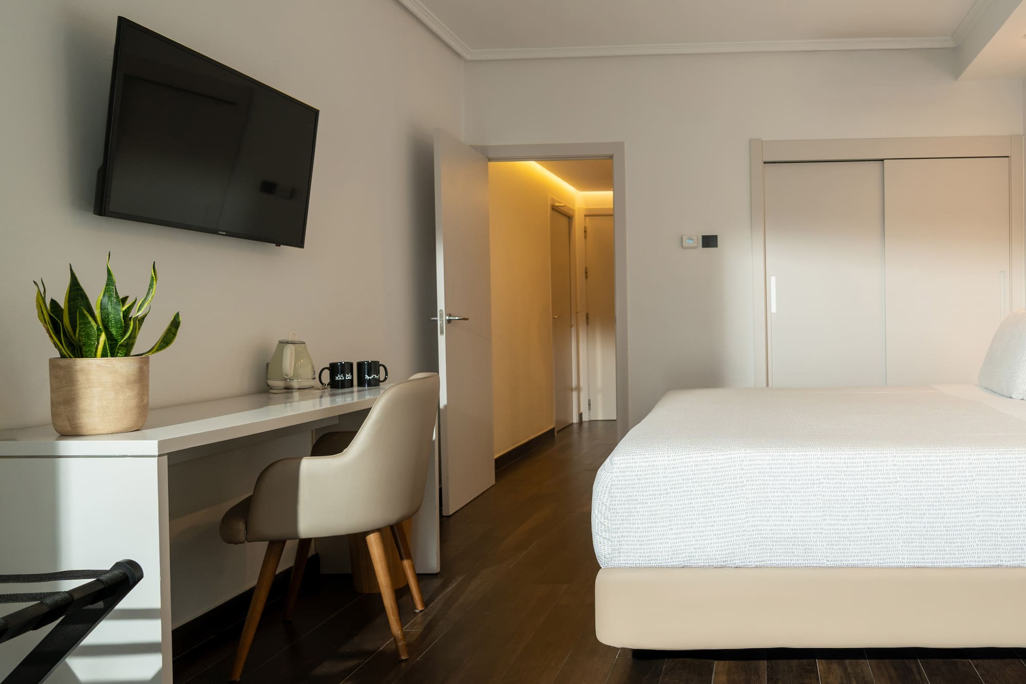 a room with a bed and a desk and a tv