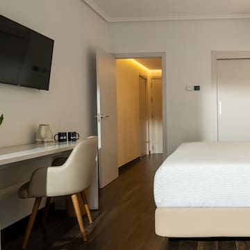 a room with a bed and a desk and a tv