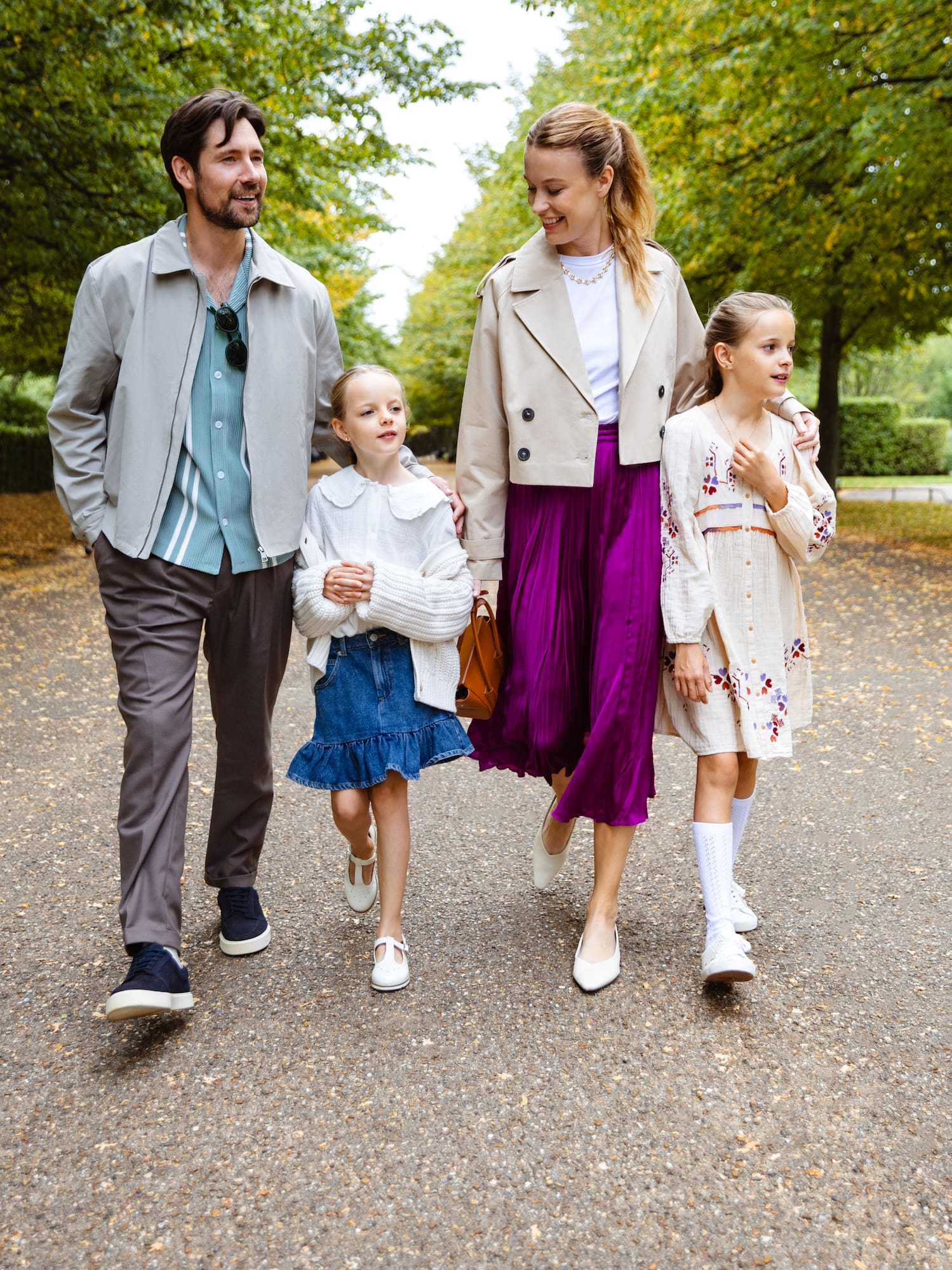 a man and woman walking down a path with two children