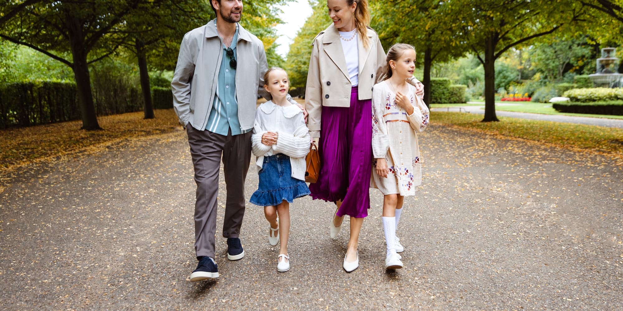 a man and woman walking down a path with two children