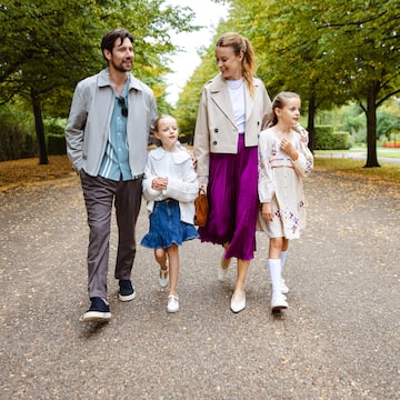 a man and woman walking down a path with two children