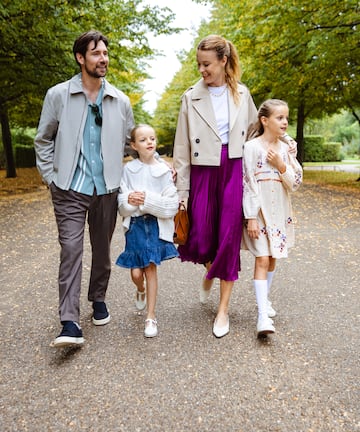 a man and woman walking down a path with two children