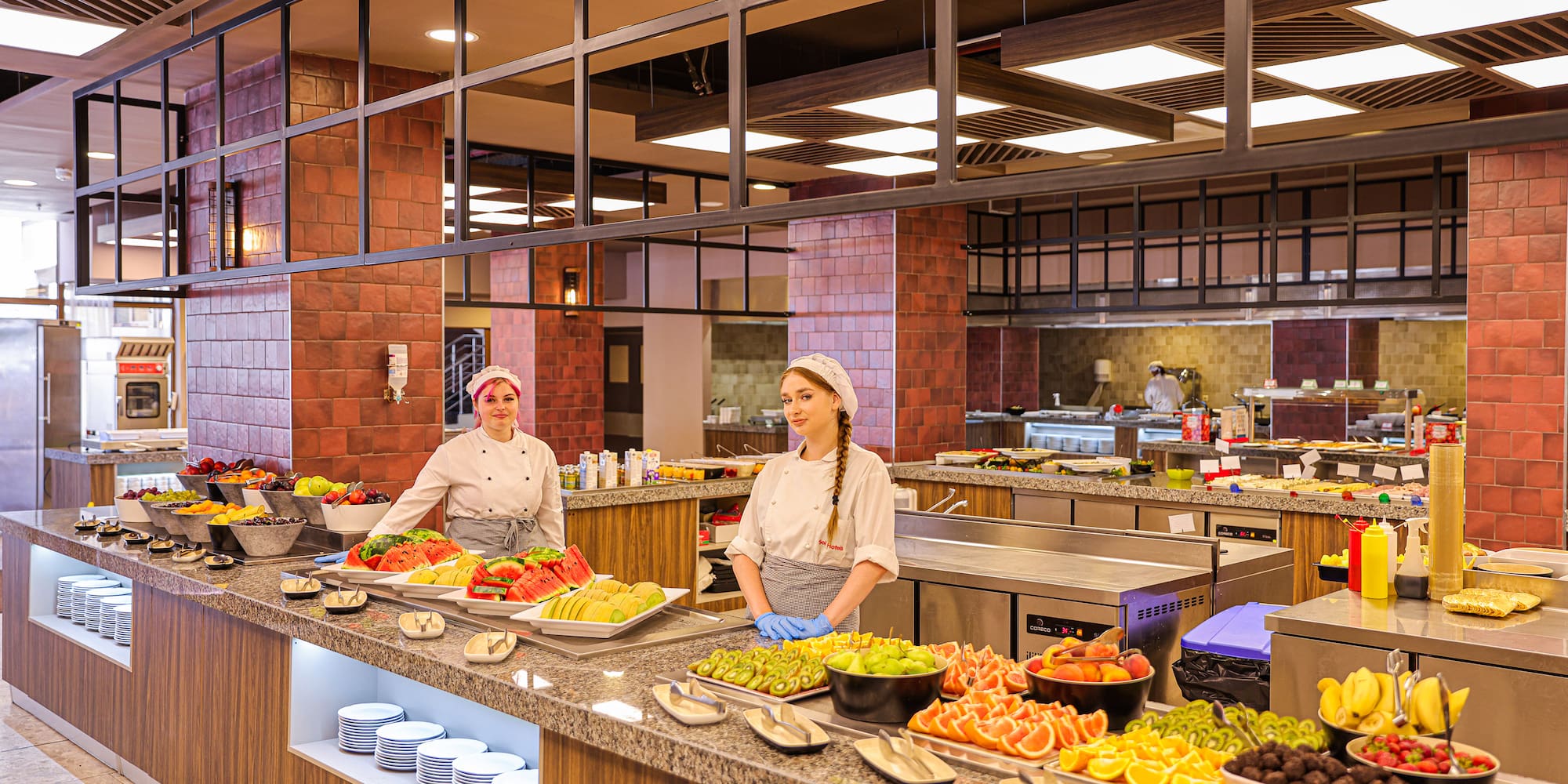 two women in a kitchen with food on the counter