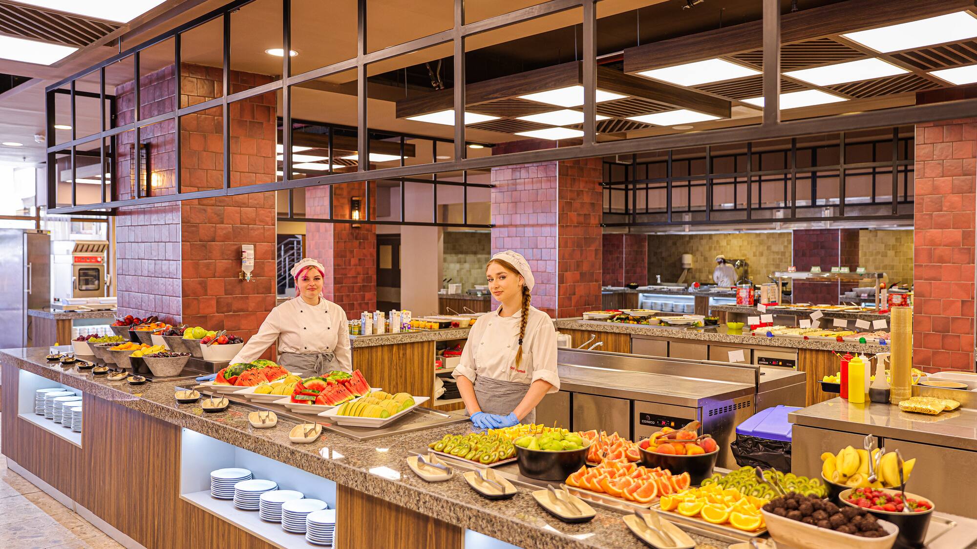 two women in a kitchen with food on the counter