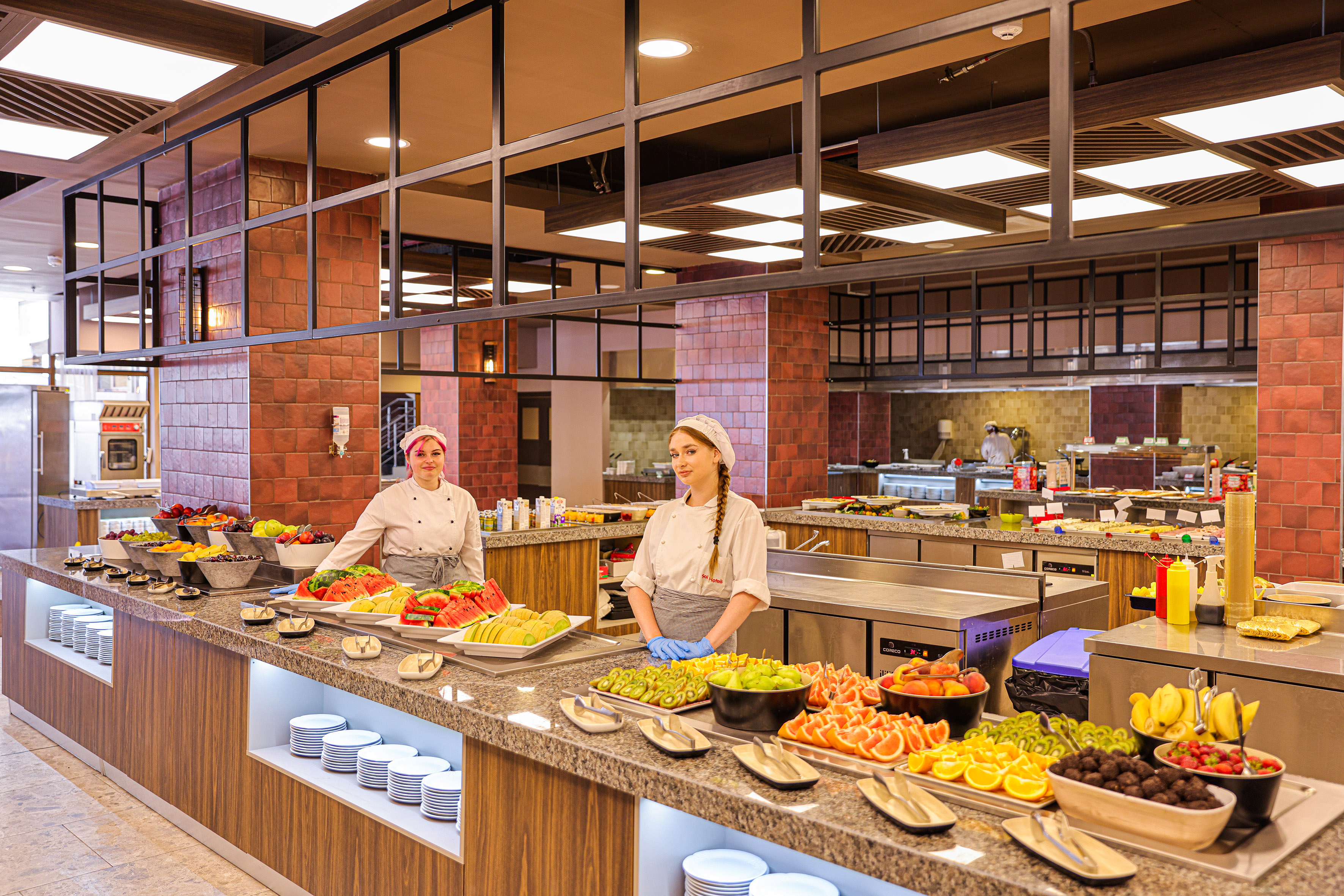 two women in a kitchen with food on the counter