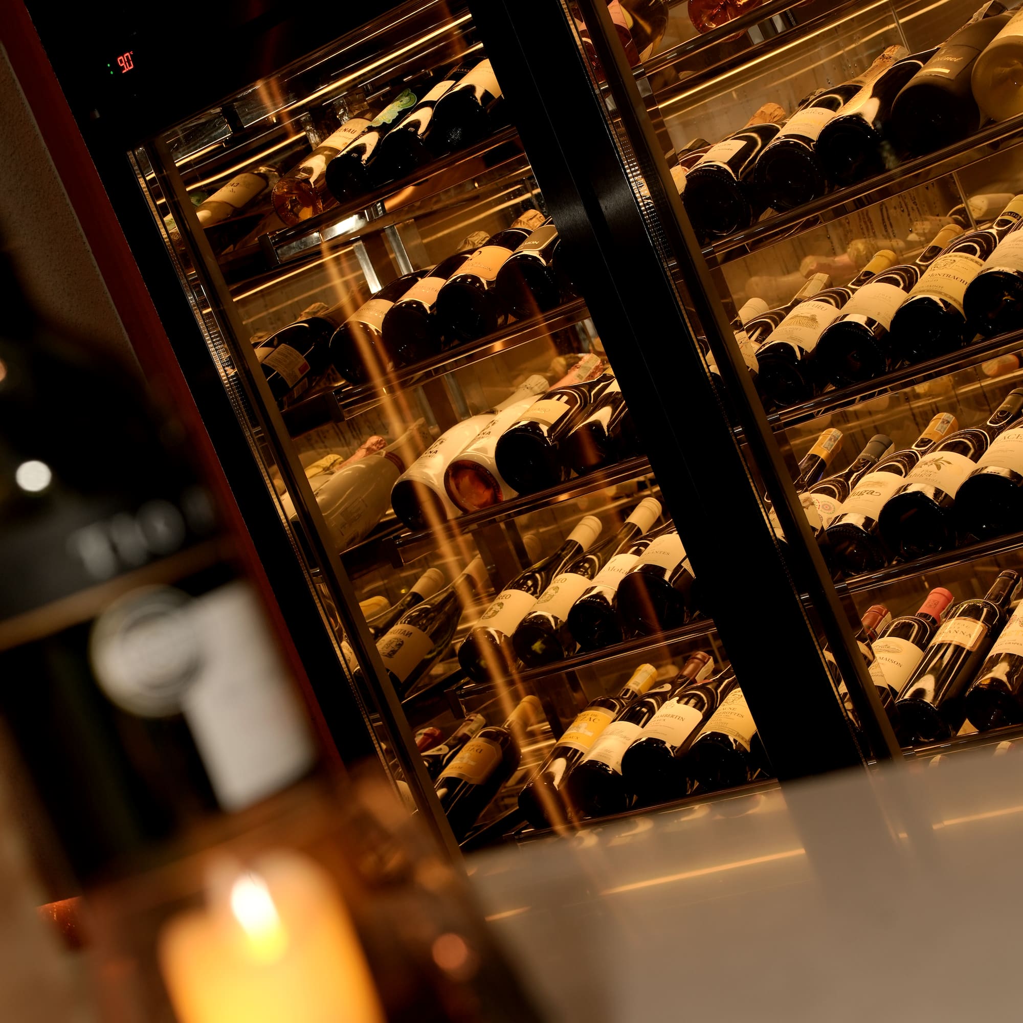 a wine cooler with bottles of wine