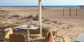 a table and chairs on a beach