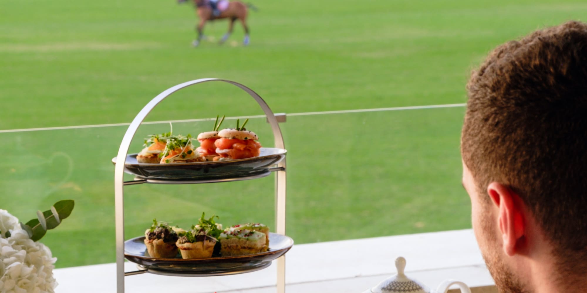 a man sitting at a table with a horse in the background