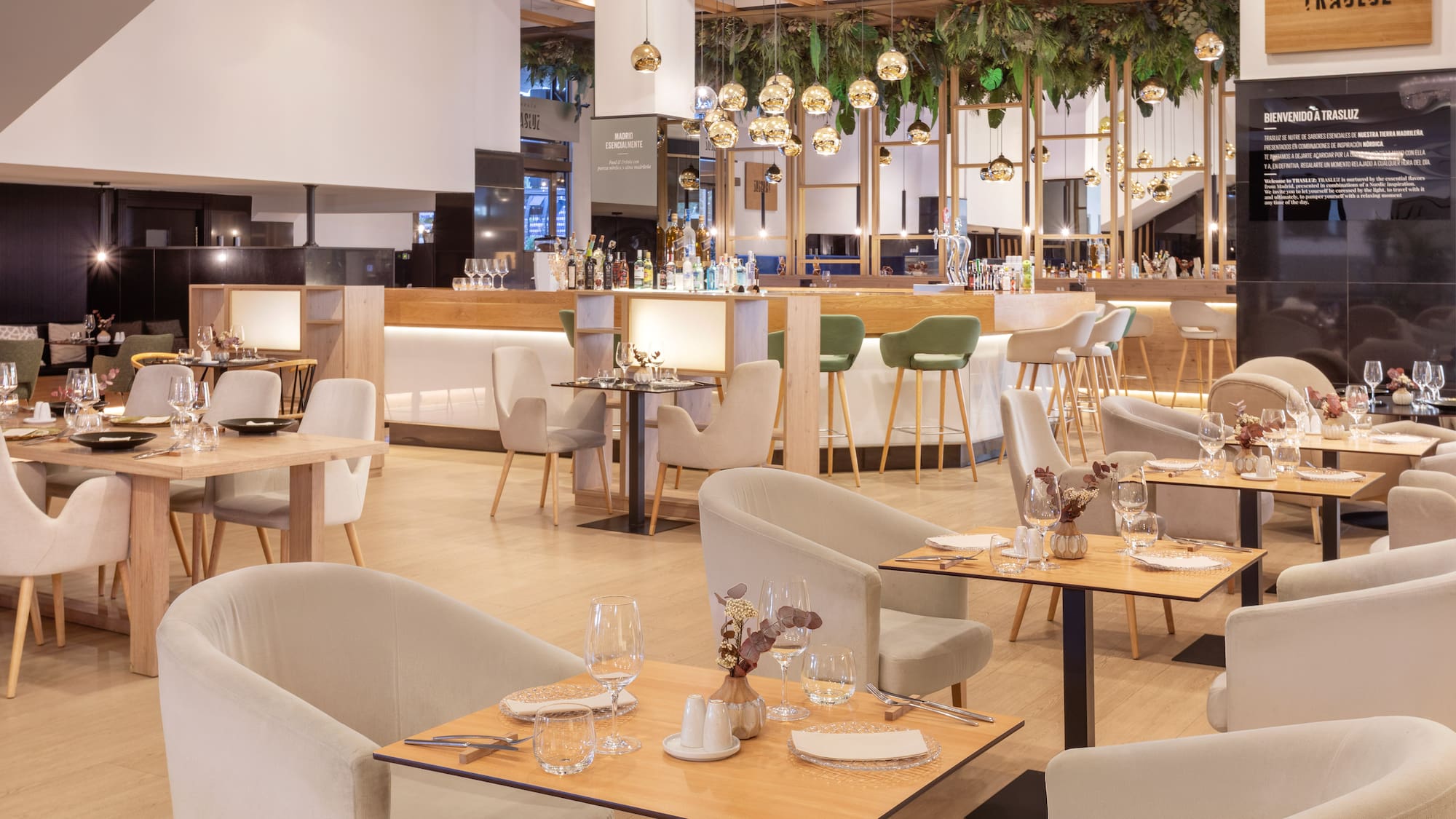 Trasluz restaurant interior: modern bar, elegant dining tables, lush greenery.