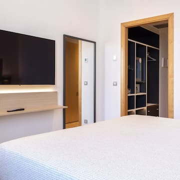 a bedroom with a tv and a bed