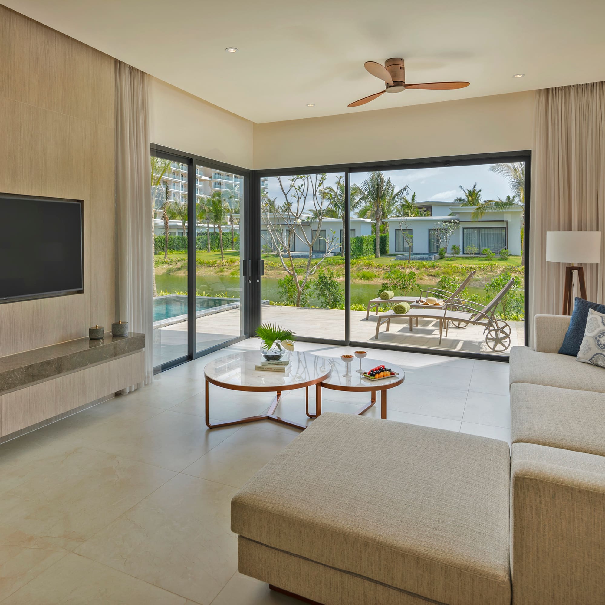 a living room with a large glass door and a television