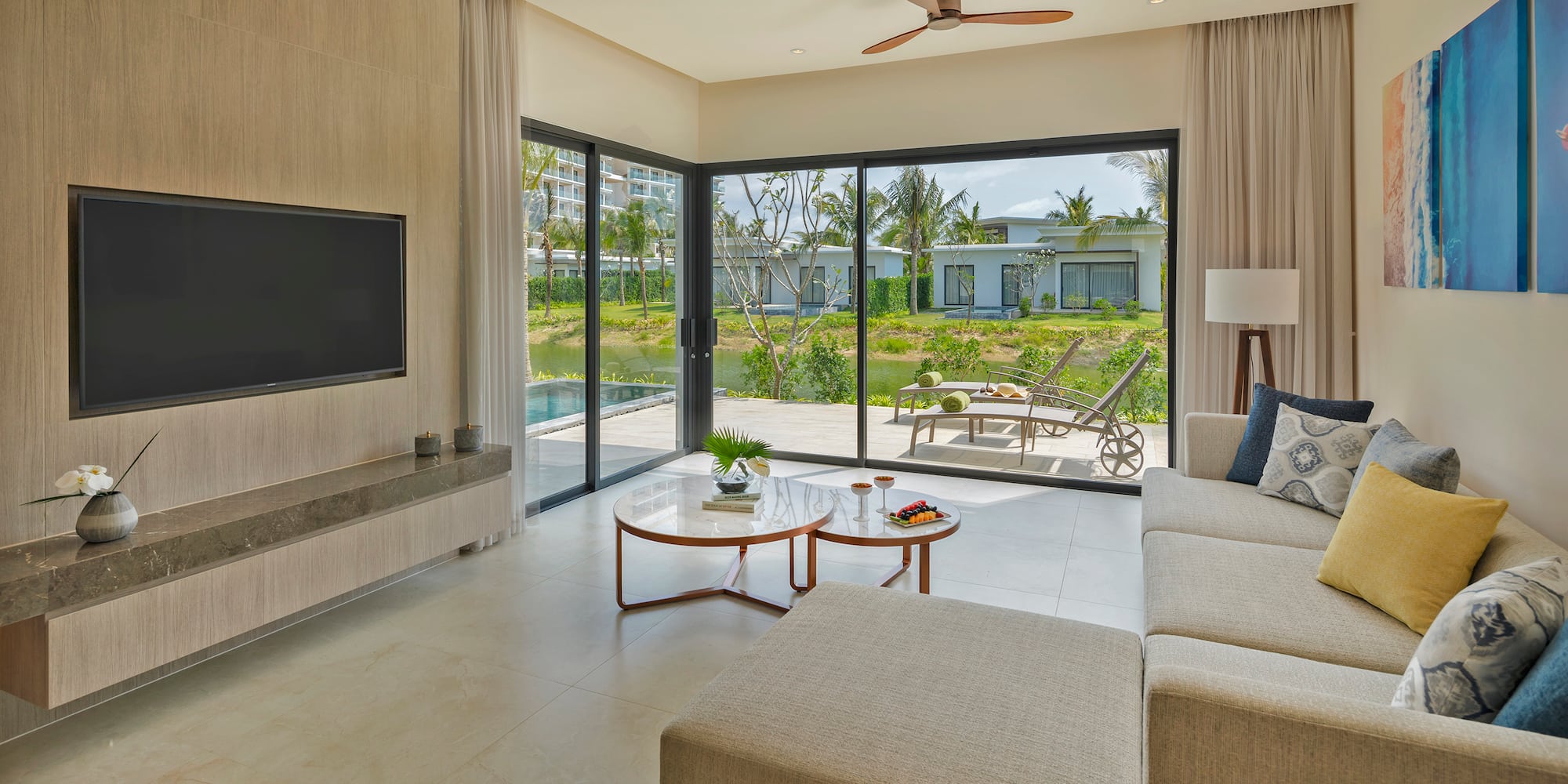 a living room with a large glass door and a television