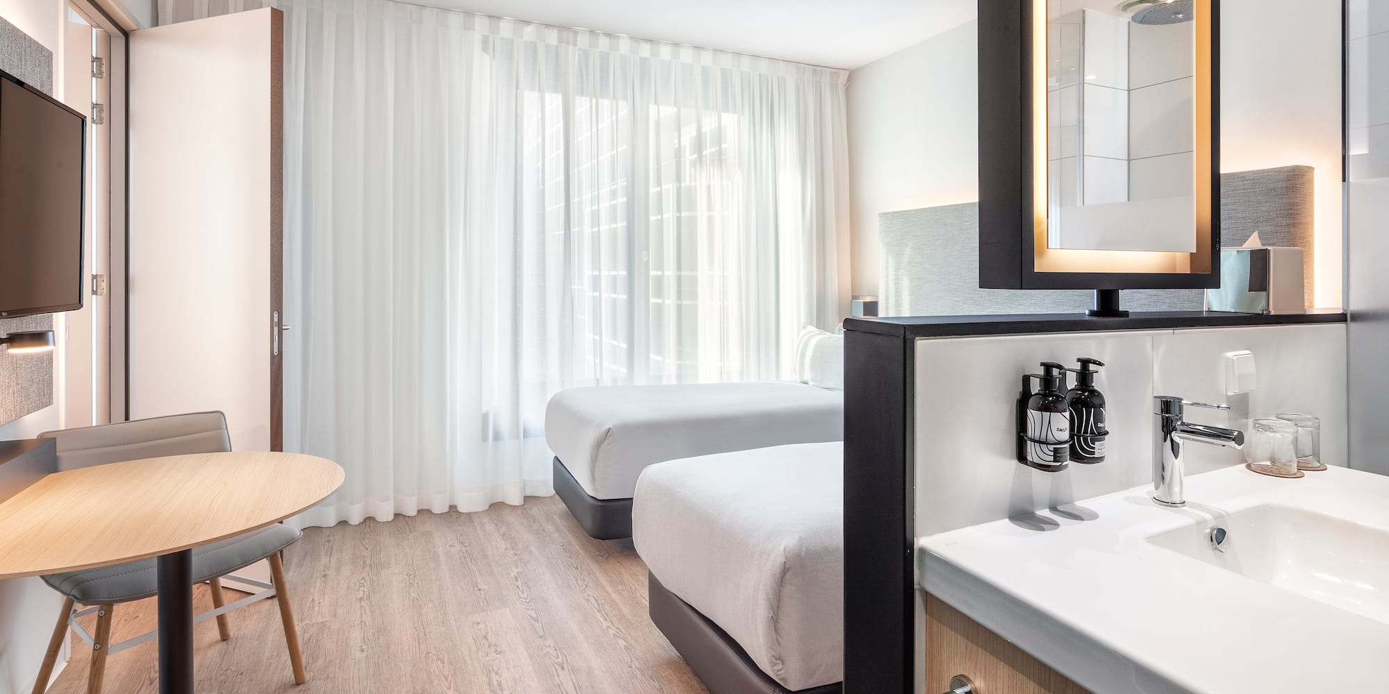 a room with two beds and a mirror