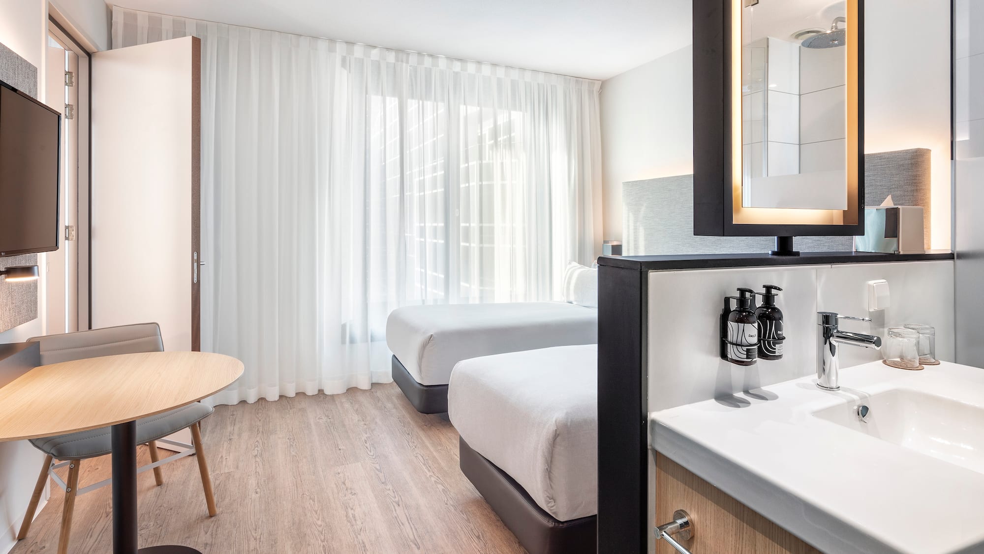 a room with two beds and a mirror